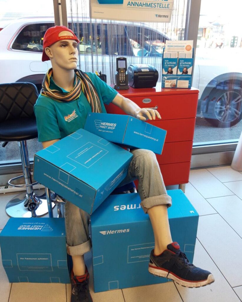 Stilisierter Mann mit Paketen im Hermes Paketshop