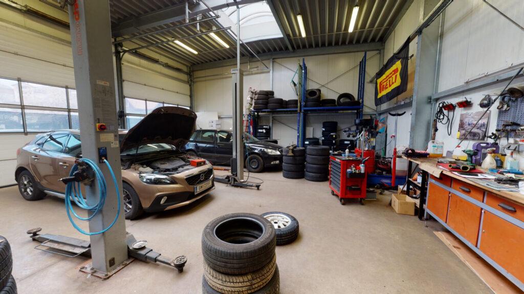 Werkstatt mit zwei Autos und Reifenlager
